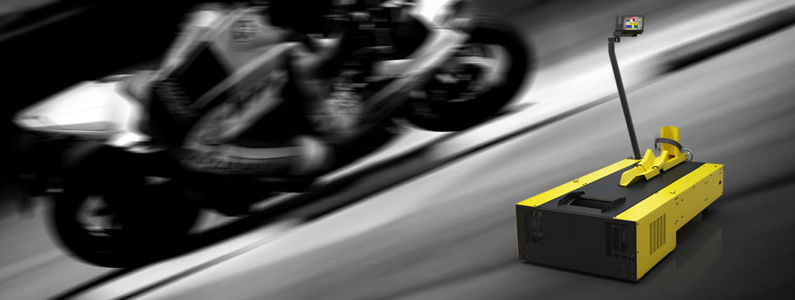 A guy with a black jacket on riding a black motorcucle looking backwards at the camera